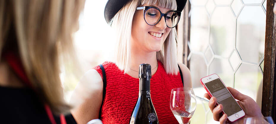 Italien-Wein-Prosecco-Valdobbiadene-Winzerin in rotem Kleid beim Ausschank
