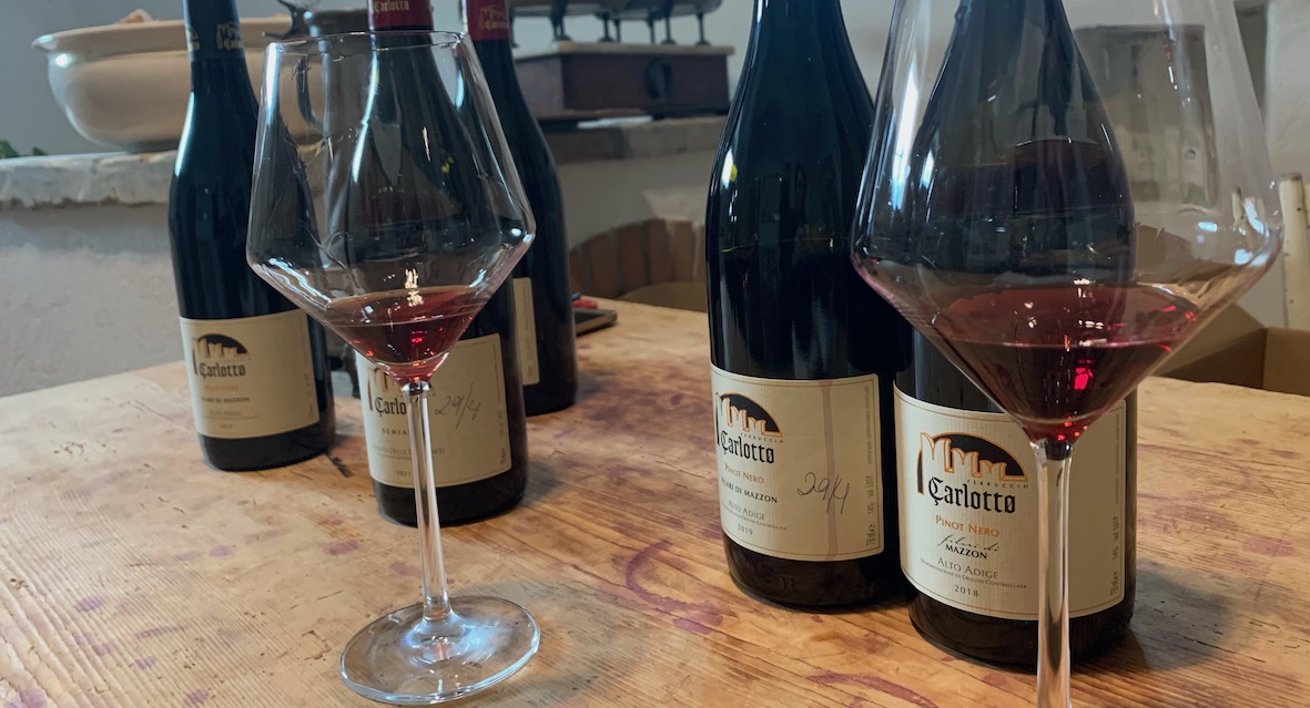 Pinot Noir Weine von Carlotto in Südtirol auf altem Holztisch mit Burgundergläsern