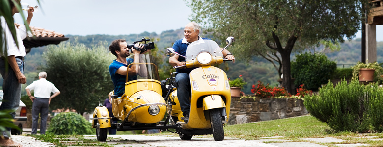 Collio-Winzer Edi Keber mit Filmemacher Daniel Hartlaub auf seiner Vespa, Roller mit Sozius-Sitz, im Weingut in Zella, Steffen Maus mit Weinglas am linken Bildrand